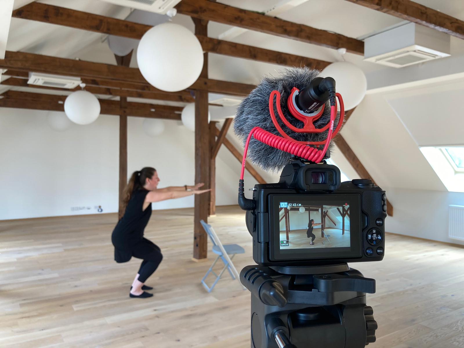 Fotografie ženy, která dělá dřepy před kamerou