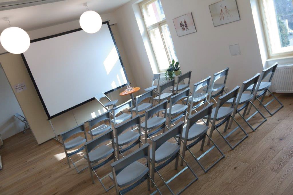 Fotografie sdíleného prostoru s židlemi v divadelním uspořádání